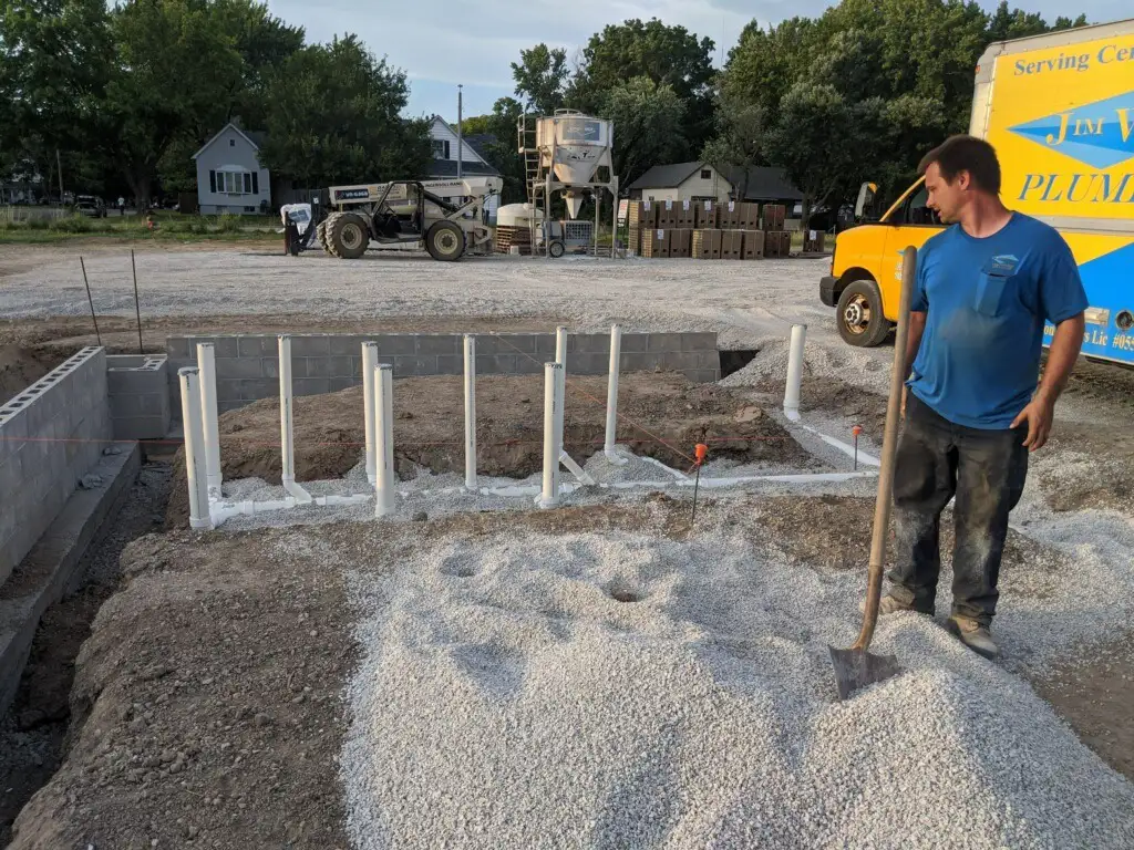 Jim Wilson Plumbing, employee helping to install piping on build site - Springfield, IL